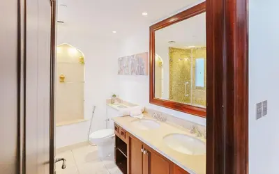 a bathroom with a sink and a toilet and a mirror at Elegant 2BR Apartment in Yansoon 3 with Burj Khalifa Views in Dubai