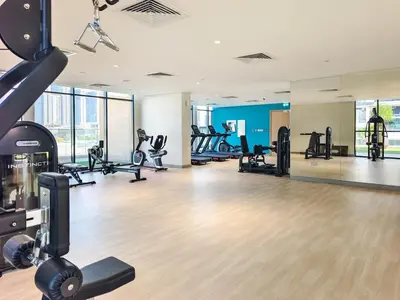 a gym with treadmills and cardio equipment in a building at Relaxing Studio Retreat in Vibrant Meydan City in Dubai