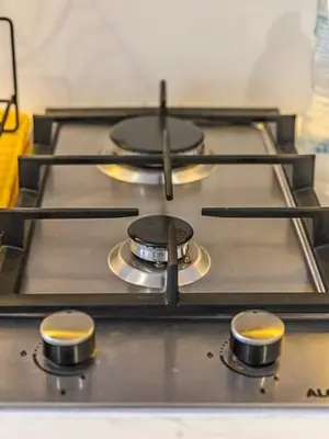 a stove top with three burners on it at Relaxing Studio Retreat in Vibrant Meydan City in Dubai