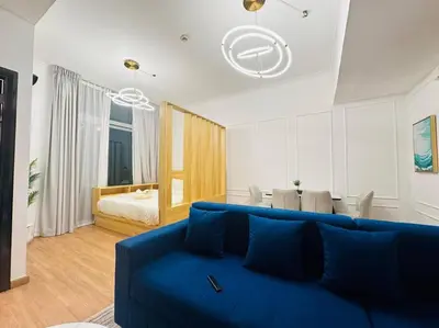a living room with a blue couch and a bedroom at Stunning Newly Furnished Apartment Dubai Marina in Dubai