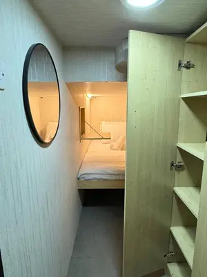 a small room with a bed and a mirror at Capsule Hostel Room in Business Bay Near Downtown in Dubai