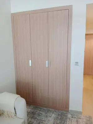 a large wooden cabinet in a room with a couch at Stonetree - Studio Unit at Azizi Riviera 45 in Dubai