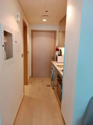 a small kitchen with a counter and a hallway at Stonetree - Studio Unit at Azizi Riviera 45 in Dubai