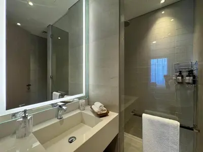 a bathroom with a sink and a shower with a mirror at Luxury Apartment in Oakley Square Residences, JVC in Dubai