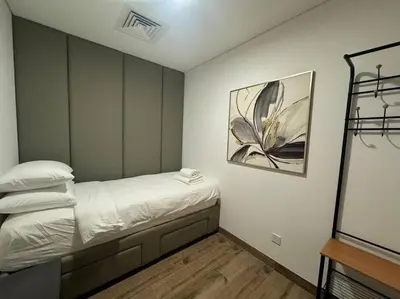a bedroom with a bed and a painting on the wall at Luxury Apartment in Oakley Square Residences, JVC in Dubai