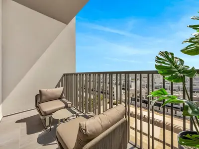 a balcony with a couch and two chairs on a balcony at Sukoon's Elegant Suite 2 in Dubai