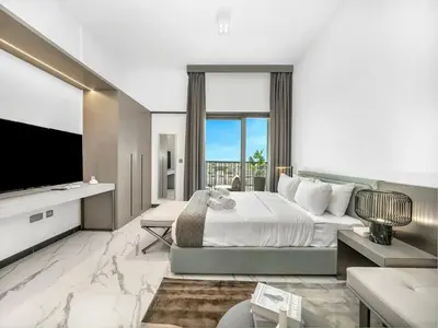a bedroom with a large bed and a television at Sukoon's Elegant Suite 2 in Dubai