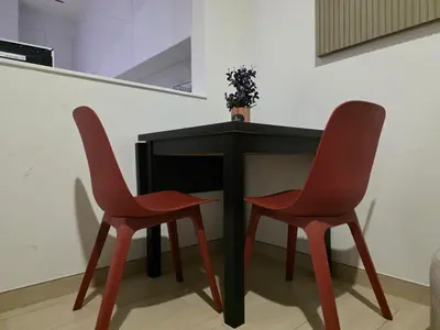 two red chairs sitting next to a black table at 1 Bed Retreat- RBE Vacation Homes-Binghatti Luna in Dubai