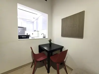a kitchen with a black table and two red chairs at 1 Bed Retreat- RBE Vacation Homes-Binghatti Luna in Dubai