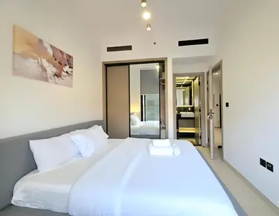 a bedroom with a large bed with white sheets at 1 Bed Retreat- RBE Vacation Homes-Binghatti Luna in Dubai