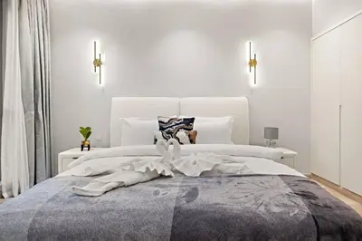a bedroom with a large bed with white walls at FIRST CLASS 2BR Incredible Burj Khalifa View in Dubai
