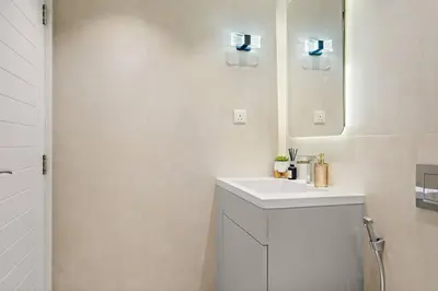 a white bathroom with a sink and a mirror at FIRST CLASS 2BR Incredible Burj Khalifa View in Dubai