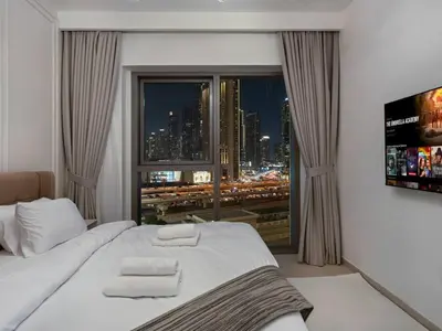 a bedroom with a bed with a view of a city at 2BR near Dubai Mall, Burj views! in Dubai