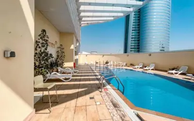 a hotel swimming pool with chairs and a building at JLT Studio apartment Goldcrest Executive in Dubai