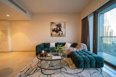 a living room with a couch and a table at Direct Burj Khalifa View I Minutes Walk to Dubai Mall I Stunning Fountain Views I One Lux Stay Grande Signature Residence in Dubai
