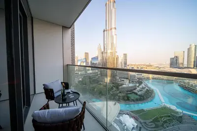 a room with a balcony with a view of the city at Direct Burj Khalifa View I Minutes Walk to Dubai Mall I Stunning Fountain Views I One Lux Stay Grande Signature Residence in Dubai