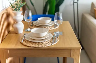 a table with two plates and wine glasses on it at GuestReady - Stunning studio in JLT in Dubai