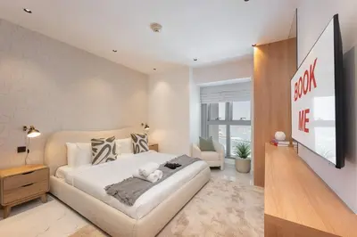 a bedroom with a large white bed and a couch at StayShort - Luxurious 2-Bedroom Apartment perfect for families in Dubai Marina in Dubai