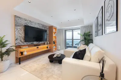 a living room with a white couch and a flat screen tv at StayShort - Luxurious 2-Bedroom Apartment perfect for families in Dubai Marina in Dubai