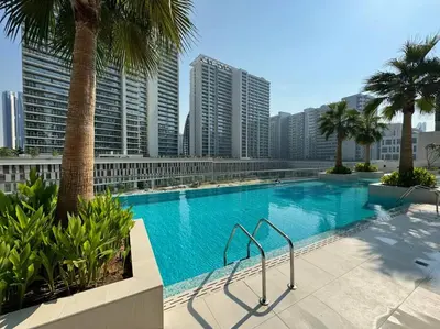 a large swimming pool with palm trees and buildings at Luxury Living Studio in the Heart of Business Bay in Dubai