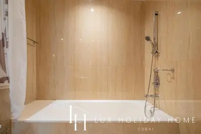 a shower in a bathroom with a bath tub at LUX The Shemara Marina View Suite in Dubai