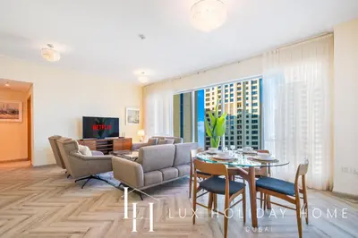 a living room with a table and chairs at LUX The Shemara Marina View Suite in Dubai