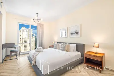a bedroom with a large bed and a window at LUX The Shemara Marina View Suite in Dubai