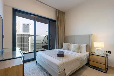 a hotel room with a bed and a large window at Livbnb-Classy 2B with Jacuzzi & BurjKhalifa View in Dubai