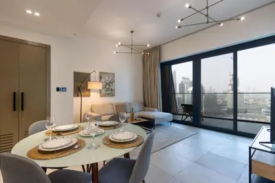 a dining room and living room with a table and chairs at Livbnb-Classy 2B with Jacuzzi & BurjKhalifa View in Dubai