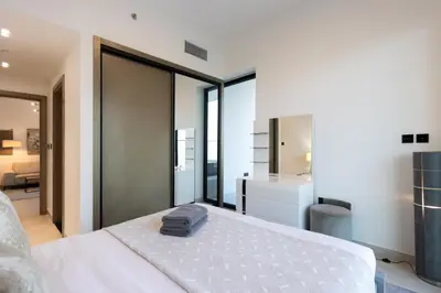 a bedroom with a white bed and a bathroom at Livbnb-Classy 2B with Jacuzzi & BurjKhalifa View in Dubai