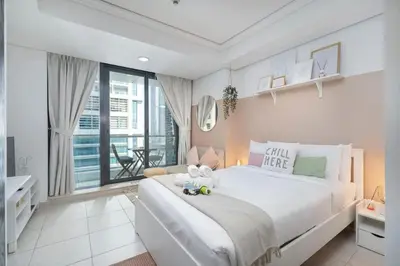 a bedroom with a large white bed with stuffed animals on it at Waves - Cozy Studio with Balcony & Partial Lake Views in Dubai