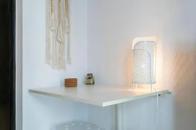 a white shelf in a white wall with a lamp at Waves - Cozy Studio with Balcony & Partial Lake Views in Dubai