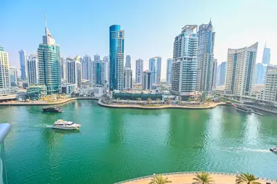 a view of a city with a river with a boat at Luxury 1 Bed with full Marina View - Emaar Park Island in Dubai