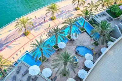 an overhead view of a beach with palm trees and a pool at Luxury 1 Bed with full Marina View - Emaar Park Island in Dubai