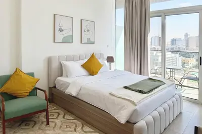 a bedroom with a bed and a window and a chair at Bloom Tower C - JVC by Golden Casa in Dubai