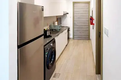 a kitchen with a stainless steel refrigerator and a dishwasher at Bloom Tower C - JVC by Golden Casa in Dubai