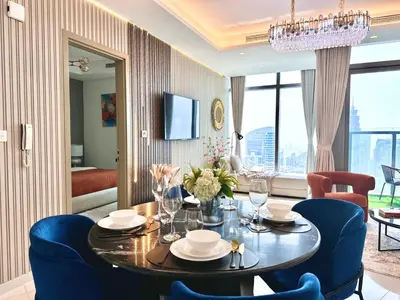 a dining room with a table and blue chairs at Highest Infinity Pool Burj Khalifa View in Dubai