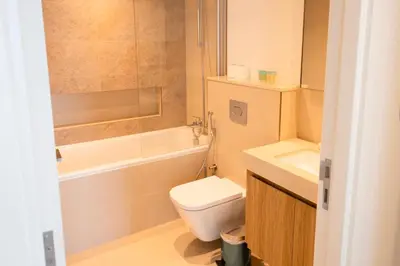 a bathroom with a toilet and a tub and a sink at INA HOMES - 1BHK Downtown Views Direct Access to Dubai Mall in Dubai