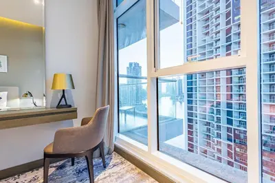a chair in a room with a large window at Spacious Studio with Pool - Canal & Burj Views in Dubai