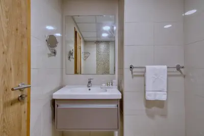 a white bathroom with a sink and a mirror at Modern Retreat with Dubai Marina View in Dubai