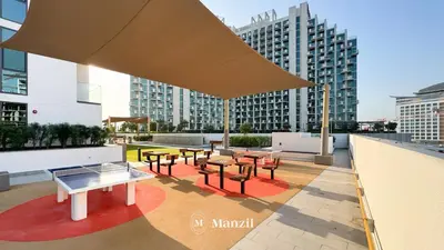 a rooftop patio with tables and chairs on a building at 1BR Apt Near Downtown Dubai with Pool & Skyline Views in Dubai