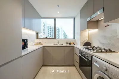 a white kitchen with a sink and a stove at 1BR Apt Near Downtown Dubai with Pool & Skyline Views in Dubai