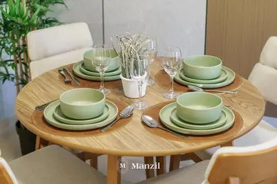 a wooden table with green dishes and wine glasses at 1BR Apt Near Downtown Dubai with Pool & Skyline Views in Dubai
