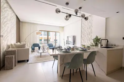 a kitchen and living room with a table and chairs at Frank Porter - Al Samar 1 in Dubai