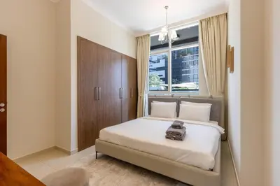 a bedroom with a bed with a bag on it at Livbnb - 2B Maid's in Dunya, 5Min Walk to Dubai Mall in Dubai