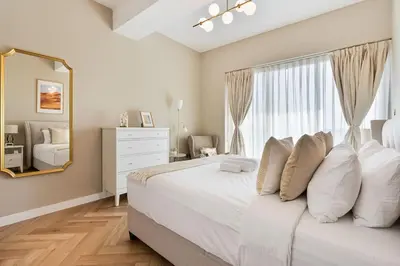 a bedroom with a bed with white pillows and a window at Urban Oasis 1BR in Armada with Cityscape Views in Dubai