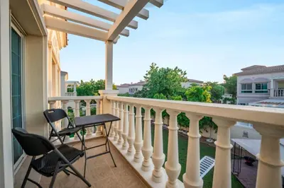 a balcony with two chairs and a table at Beautiful 2BR Villa in JVT in Dubai