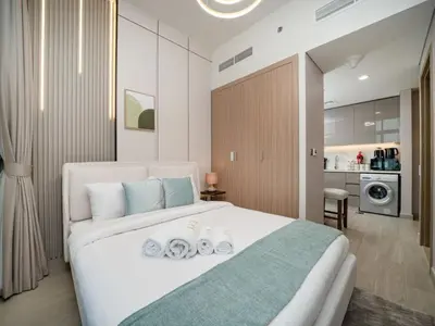 a bedroom with a large white bed with towels on it at Elegant Studio in Azizi Riviera with Luxury Amenities in Dubai