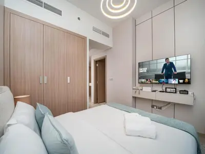 a bedroom with a bed with a flat screen tv at Elegant Studio in Azizi Riviera with Luxury Amenities in Dubai