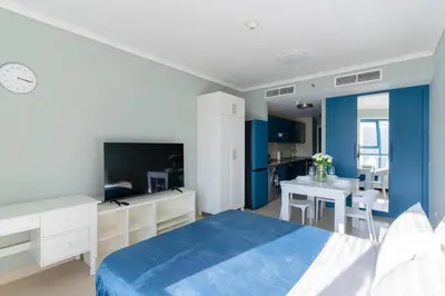 a bedroom with a blue bed and a dining room at JLT Nice Studio apartment High floor View in Dubai